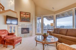 a living room with a couch and a table and a fireplace at River Ridge 421AB - Meredith Lodging in Bend