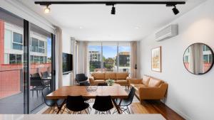 a living room with a table and chairs at District Apartments Fitzroy in Melbourne