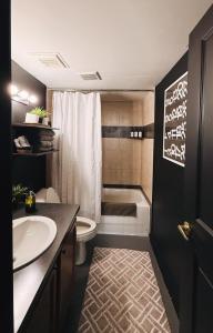 a bathroom with a toilet and a sink and a tub at 420 Friendly BOHO Loft Downtown KING suite FREE parking in Detroit