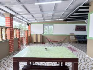 Cette chambre comprend une table et un hamac. dans l'établissement Teratak Idaman, à Rengit