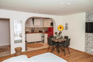 a living room with a table and a kitchen at Motel Kalos in Haiger