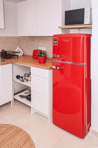 a red refrigerator in a kitchen with a microwave at Motel Kalos in Haiger