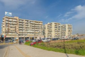 een groot appartementencomplex met auto's voor het gebouw bij Angelo Maison in Thessaloniki