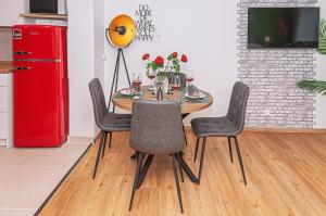 a dining room table with chairs and a red refrigerator at Motel Kalos in Haiger