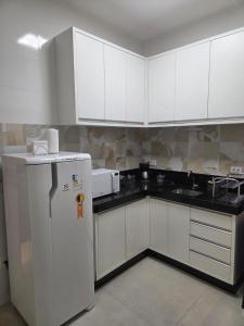 a kitchen with white cabinets and a refrigerator at Casa do Mateus no bairro Pilar in Ouro Preto +25 photos