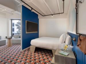 a hotel room with a bed and a tv at TRIBE Auckland in Auckland