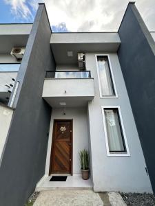 una casa con una puerta de madera y una ventana en Casa Familiar - Próximo ao Aeroporto - WI-FI - Garagem Privativa GEM17, en Joinville