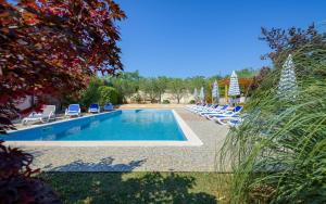 una piscina con sedie a sdraio accanto al resort di Family-friendly apartments with swimming pool Basanija, Umag - 3402 a Savudrija
