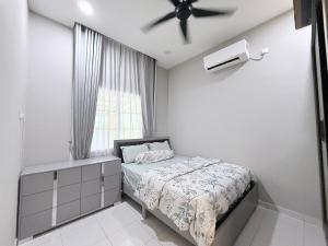 une chambre avec un lit et un ventilateur de plafond dans l'établissement Teratak Idaman, à Rengit