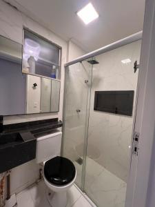 Un baño con inodoro y ducha de cristal. en Apartamento Luxo à 20 minutos do Cumbuco, en Caucaia 4 fotos más