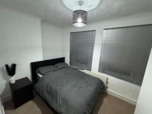 1 Schlafzimmer mit einem Bett und 2 Fenster mit Jalousien in der Unterkunft The fulfilling dover retreat in Dover