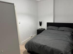 ein Schlafzimmer mit einem Bett und einer weißen Wand in der Unterkunft The fulfilling dover retreat in Dover