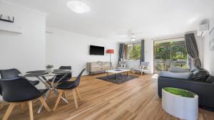 a living room with a couch and a table and chairs at Flynns Beach Seascape in Port Macquarie