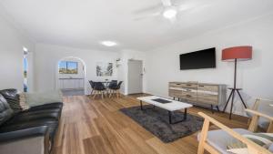 a living room with a couch and a table at Flynns Beach Seascape in Port Macquarie