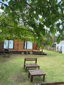 een houten hut met een bank in het gras bij Cabañas en Concordia in Concordia +6 foto's