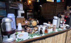 a counter with a coffee pot and cups on it at Pousada Caragua Poesia na Praia in Caraguatatuba