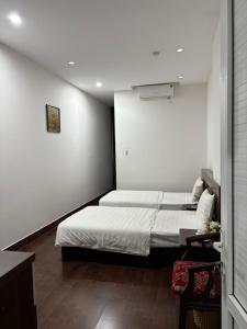 a small bedroom with a bed and a white wall at Daisy Apartment & Hotel Cẩm Phả in Hòn Một