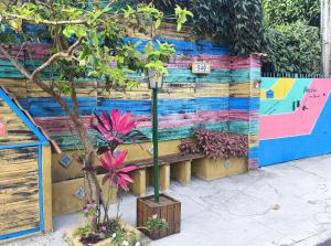 a street light with a tree in front of a wall at Pousada Caragua Poesia na Praia in Caraguatatuba