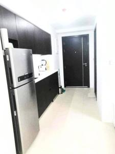 a kitchen with a refrigerator and a black door at aeon condon studio unit in Davao City +1 photo