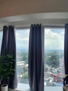 a window with blue curtains in a room at aeon condon studio unit in Davao City