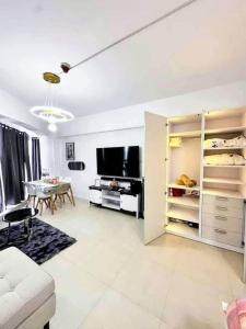 a living room with a couch and a dining room at aeon condon studio unit in Davao City