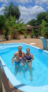 un uomo e due bambini in una piscina di RepousaAquiÓ Olímpia a Olímpia