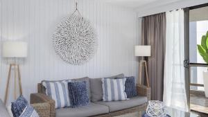 a living room with a couch with blue and white pillows at Beachside Bliss in Port Macquarie