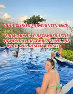 una mujer sentada en el agua de una piscina en Vista Verde Lodge, en Lanquín