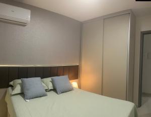 a bedroom with a bed with two pillows on it at Belize flat praia de Intermares in Cabedelo