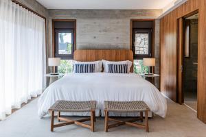 a bedroom with a large bed and two chairs at Juquehy Praia Hotel in Juquei +25 photos