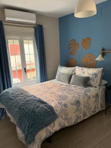 a bedroom with a bed with a blue wall at El Boulevard de Trujillo 1997 in Trujillo