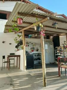 Vista Surf Pipa Hostel في بيبا: عريشة بها طاولة وكراسي ومطبخ +13 صورة