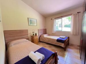 Rocco Housse في لوس هورنيلوس: غرفة نوم بها سريرين ونافذة