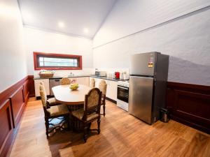a kitchen with a table and a stainless steel refrigerator at The Sienna Hunter Valley in Luskintyre