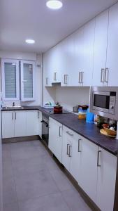 Las vegas في الكوركون: مطبخ مع دواليب بيضاء وميكرويف