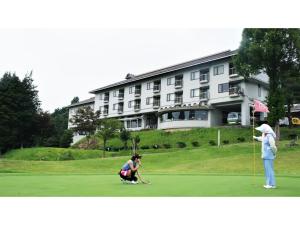a woman playing golf in front of a hotel at Utsunomiya Inter Resort Hotel - Vacation STAY 68874v in Utsunomiya +25 photos