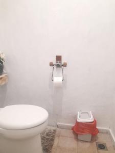a bathroom with a toilet and a camera on the wall at Little Loti Sikumana in Maulafa +40 photos