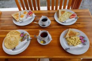 a table with plates of breakfast food and cups of coffee at Memela Bungalow in Nusa Penida +19 photos