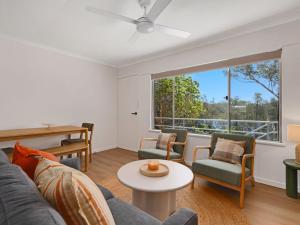 ein Wohnzimmer mit Sofa, Stühlen und einem Tisch in der Unterkunft Blue Lotus Riverfront Villas Nelligen in Nelligen