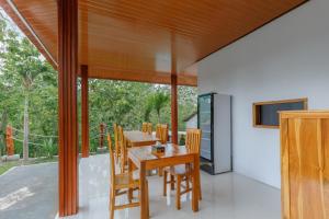 een eetkamer met een houten tafel en stoelen bij Memela Bungalow in Nusa Penida