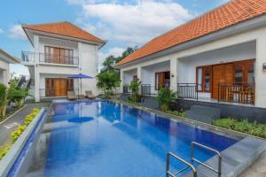 a swimming pool in front of a house at Memela Bungalow in Nusa Penida