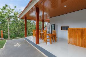 an open kitchen and dining room with a table and chairs at Memela Bungalow in Nusa Penida