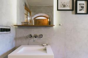 a bathroom with a white sink and a mirror at Abode Bombay in Mumbai