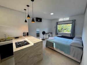 a bedroom with a bed and a kitchen with a sink at Flat Prosperidade - Completo No Centro do Capão in Vale do Capao