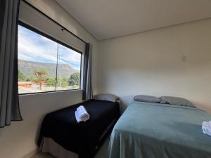 パウメイラスにあるFlat Completoのベッドと大きな窓のある寝室