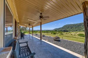 a porch of a house with a bench and a view at Frio Hills Hideaway in Leakey