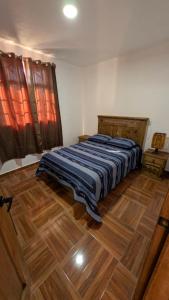 ein Schlafzimmer mit einem Bett und einem Holzboden in der Unterkunft Casa Rancho El Capulín en Grutas de Tolantongo 