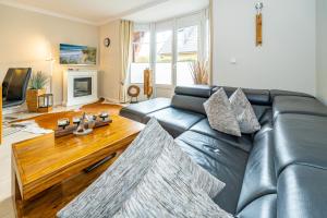 a living room with a leather couch and a coffee table at Godewind App 5 in Westerland
