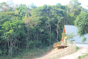 Chalé Amorência في كامبو لارغو: منزل ذو سقف أزرق بجوار غابة