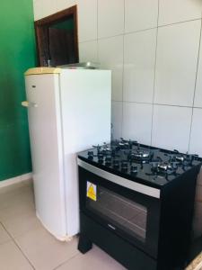 een keuken met een fornuis en een koelkast bij Casa vista da serra verde in Santana do Riacho